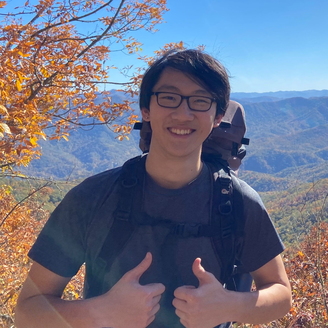 Photo of Tiger backpacking, smiling at the camera with two thumbs up
